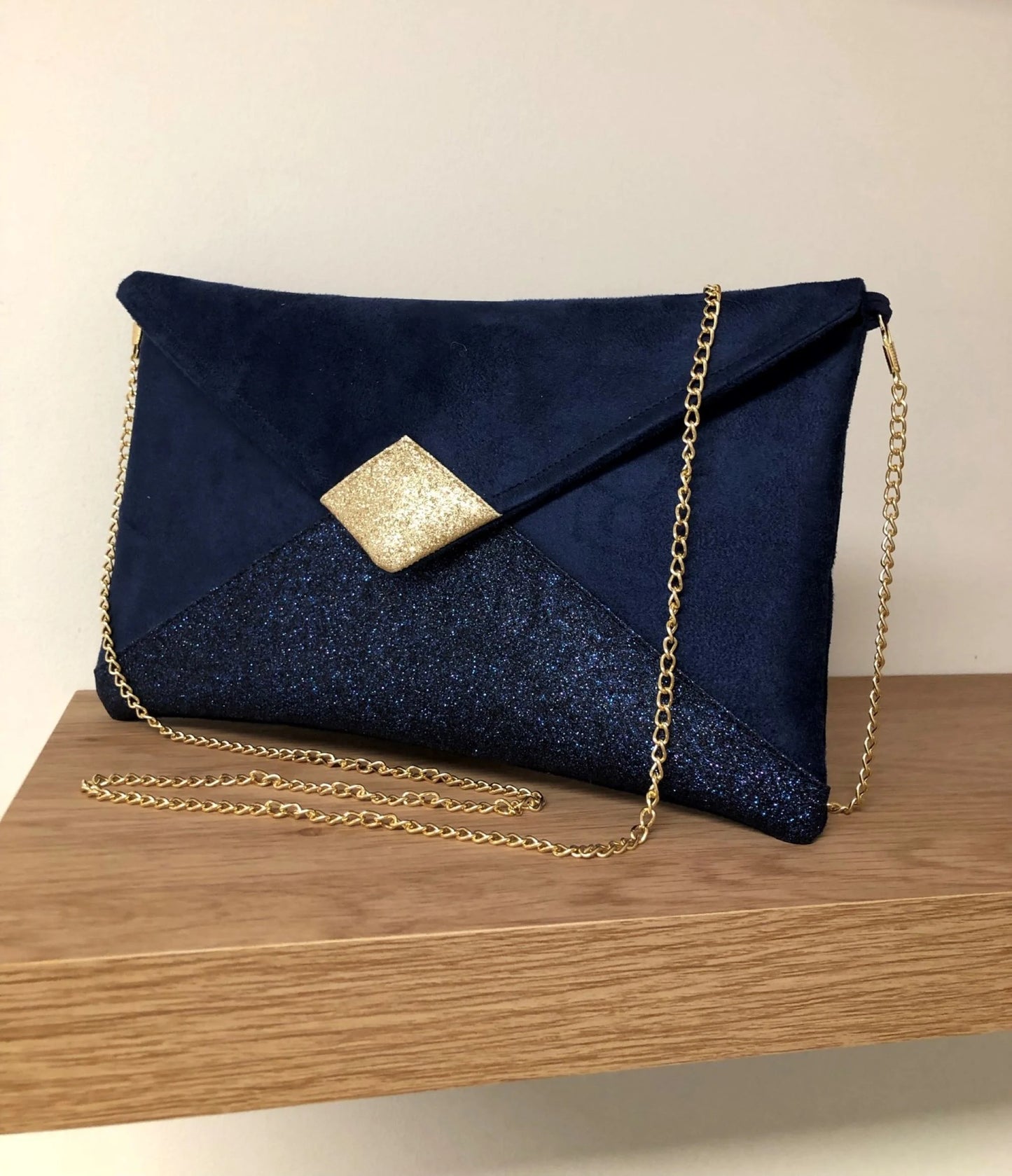 Le sac pochette Isa bleu marine et doré à paillettes, avec chainette amovible.