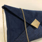Vue détaillée du sac pochette Isa bleu marine et doré à paillettes, avec chainette amovible.
