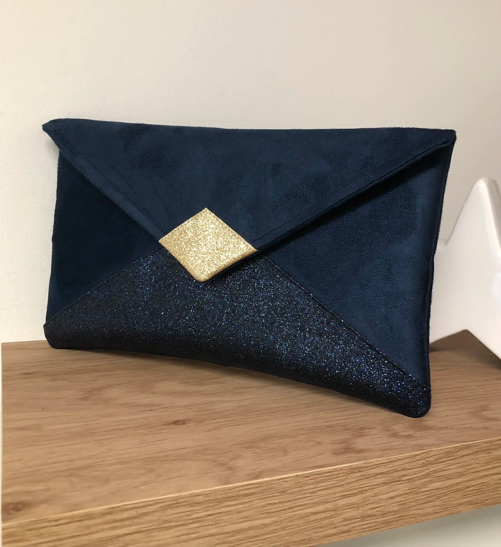Le sac pochette Isa bleu marine et doré à paillettes, sans chainette amovible.