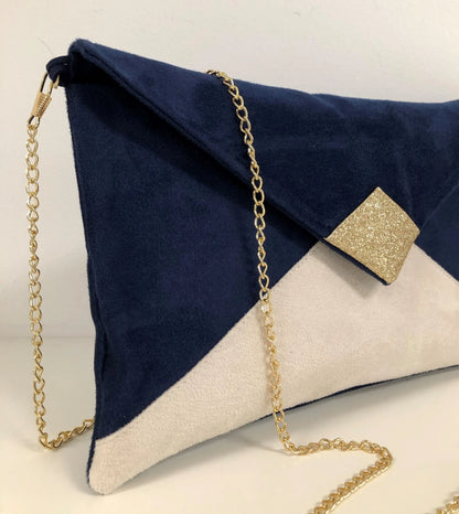 L'accroche de la chainette du sac pochette Isa bleu marine et écru à paillettes dorées.