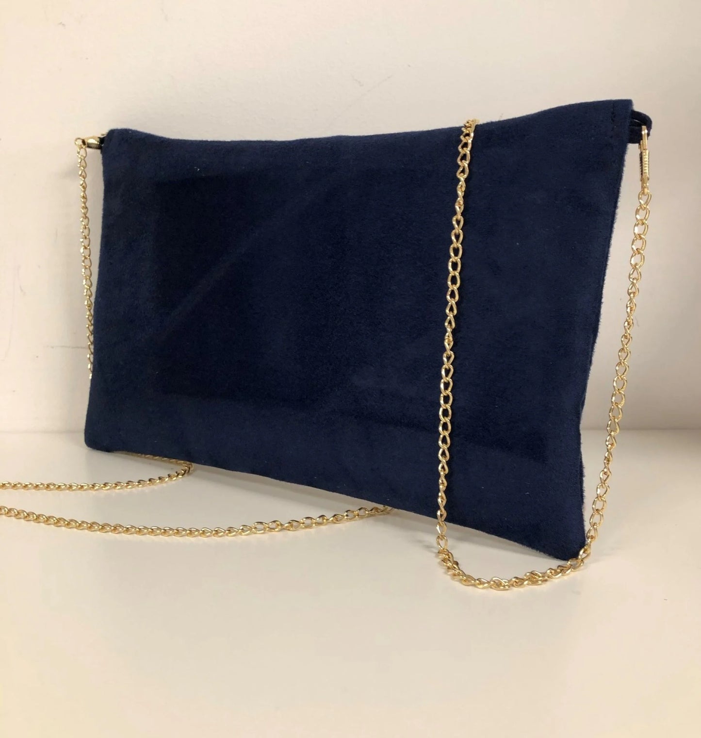 Le dos du sac pochette Isa bleu marine et écru à paillettes dorées.