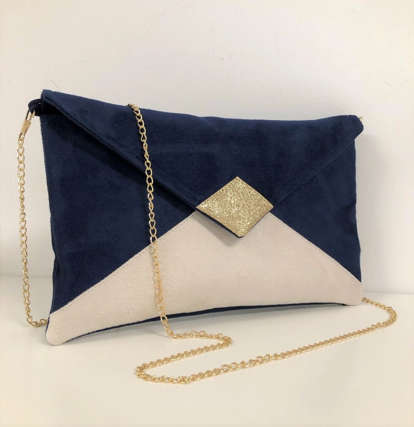 Le sac pochette Isa bleu marine et écru à paillettes dorées, face avant.