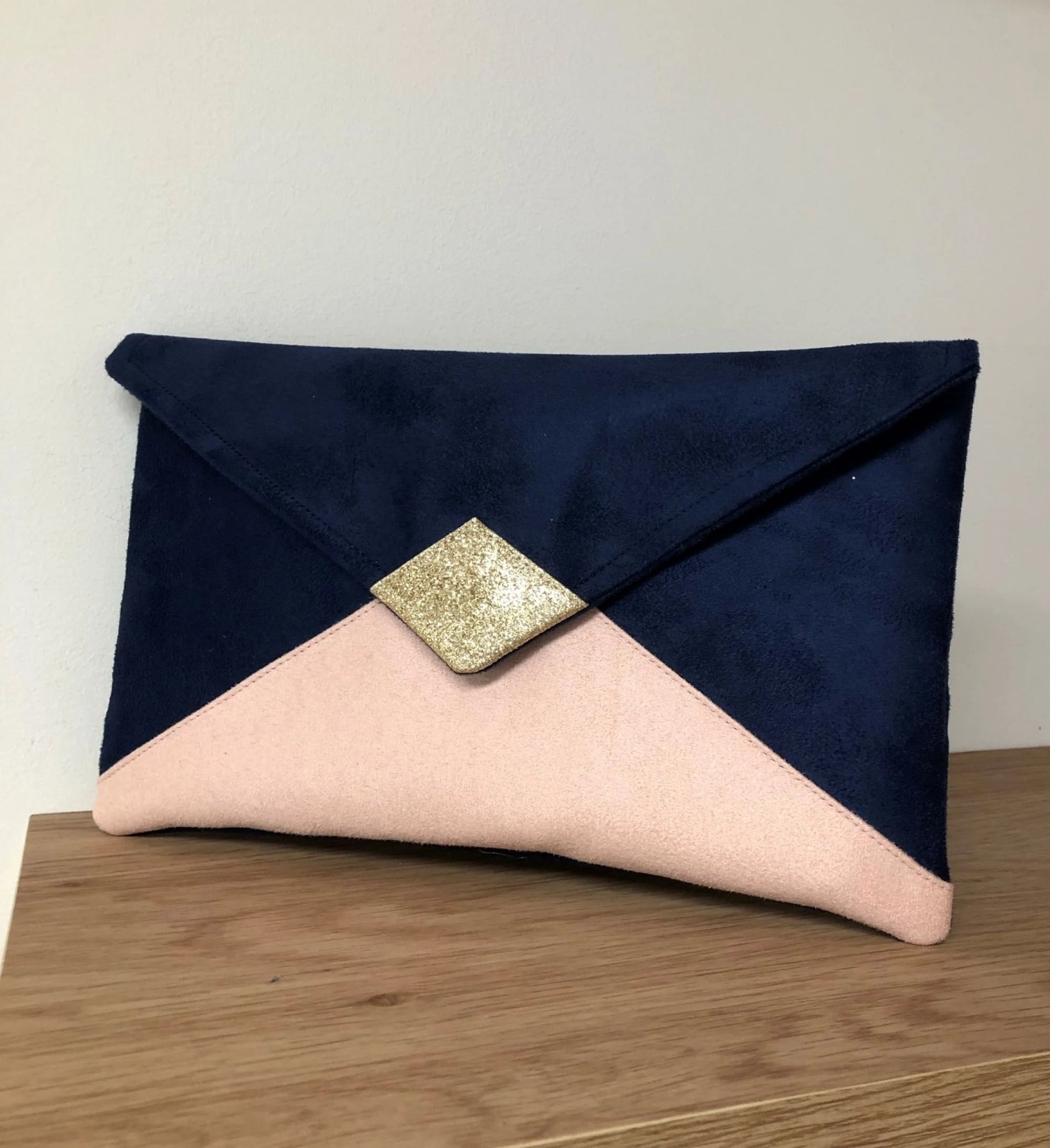 Le sac pochette Isa bleu marine et rose poudré à paillettes dorées, sans chainette amovible.