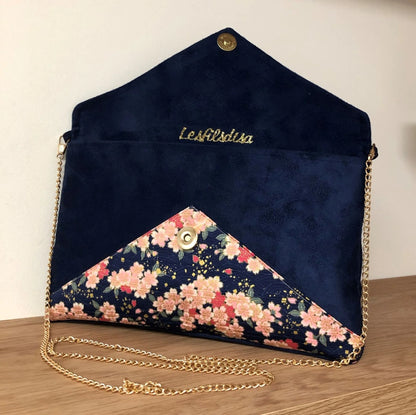 Le sac pochette Isa bleu marine à fleurs de cerisier et paillettes dorées, ouvert.