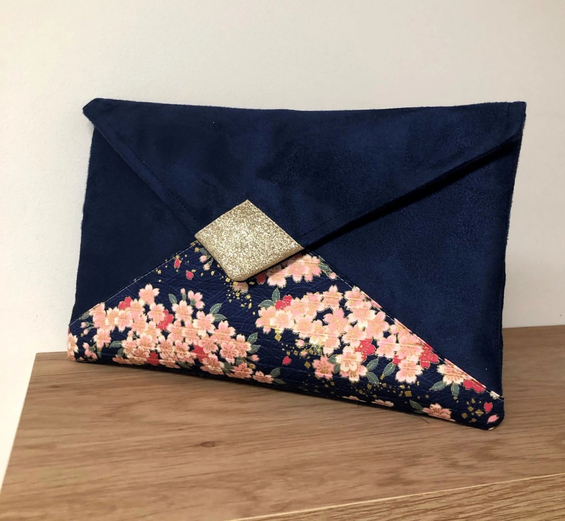 Le sac pochette Isa bleu marine à fleurs de cerisier et paillettes dorées sans chainette.
