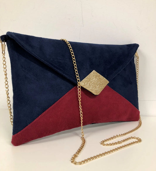 Le sac pochette Isa bleu marine et fuchsia à paillettes dorées, avec chainette amovible.