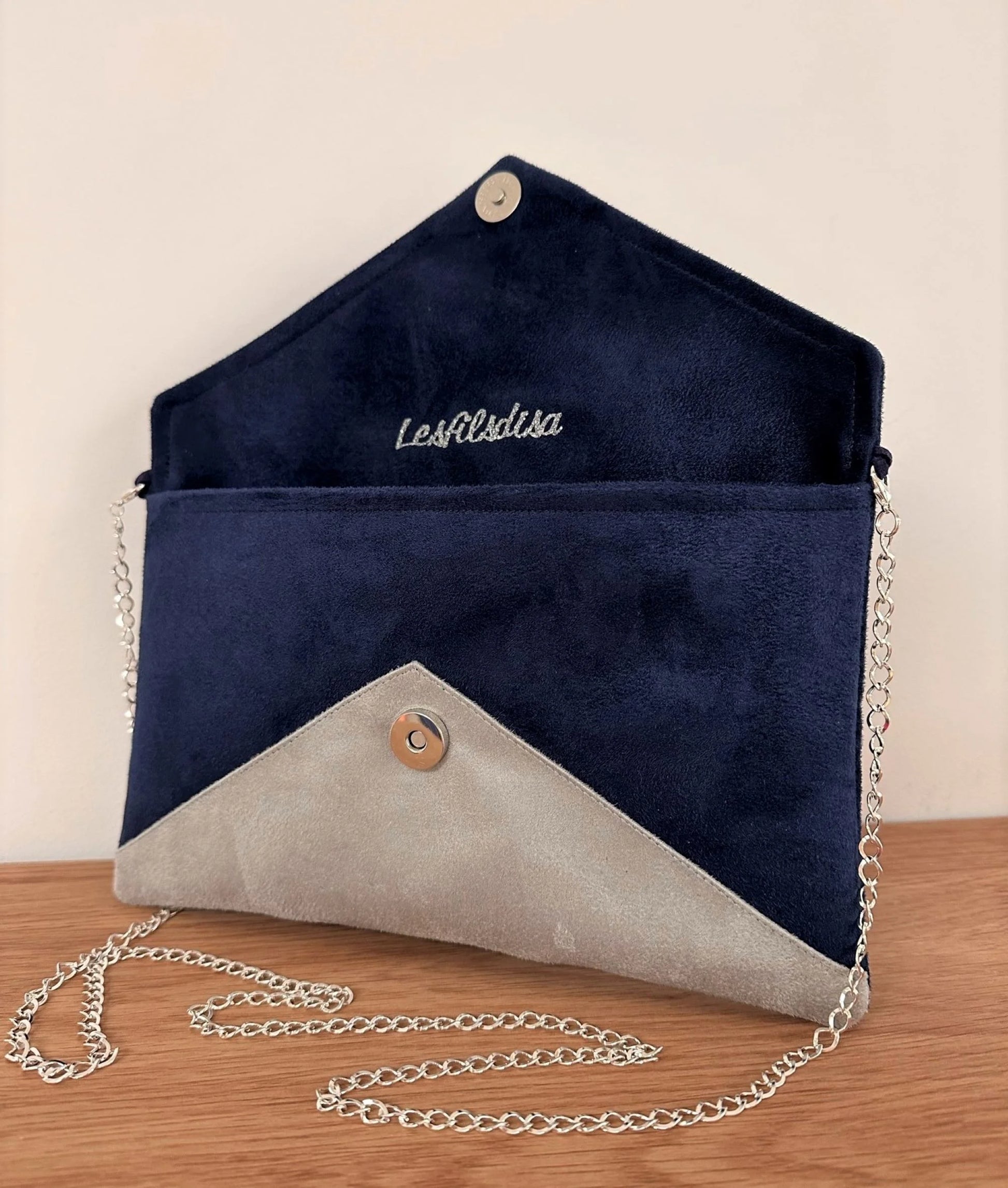 Le sac pochette Isa bleu marine et gris à paillettes argentées, avec sa chainette amovible, ouvert.