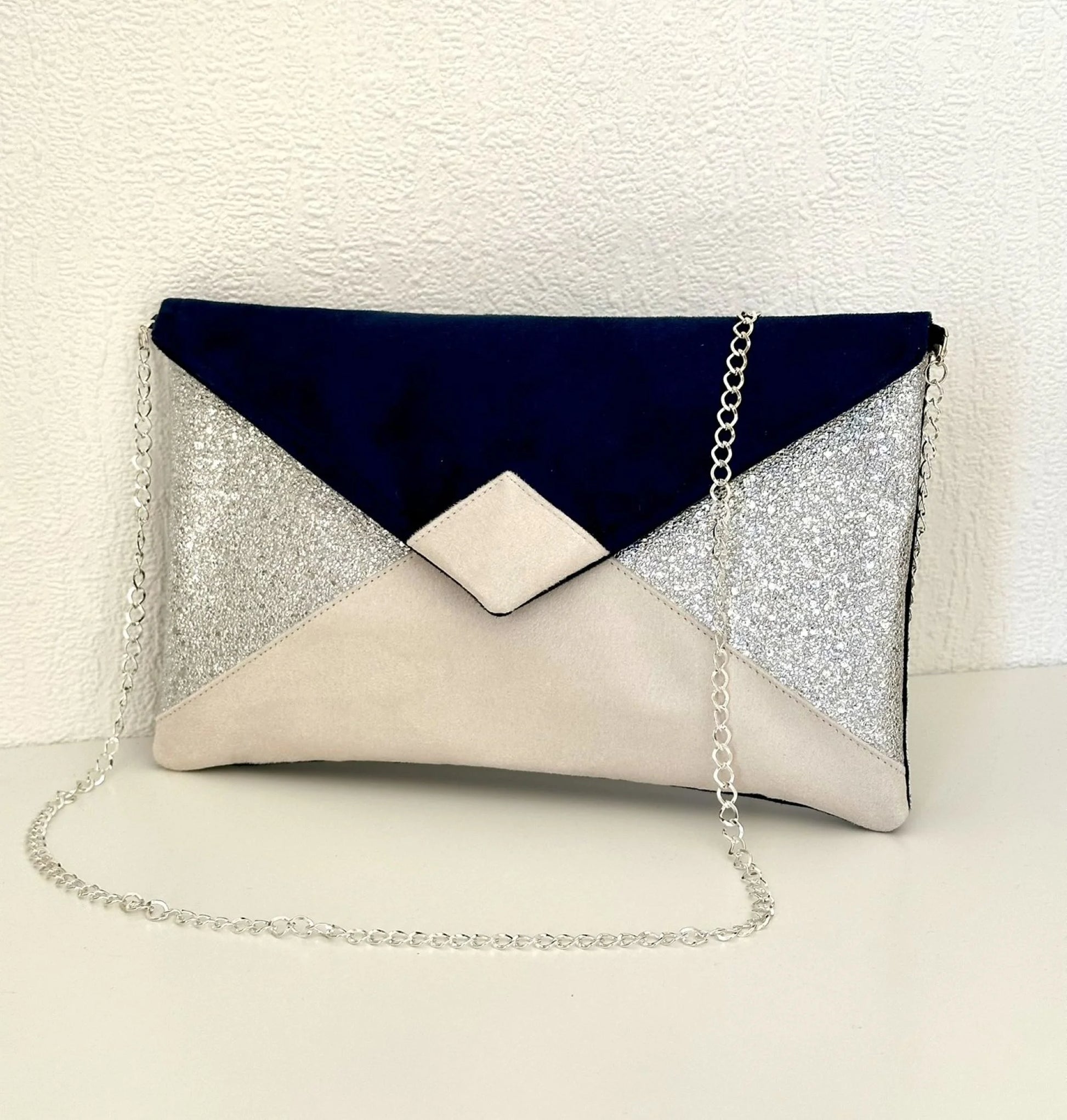 Face avant du sac pochette Isa bleu marine, ivoire et argenté.