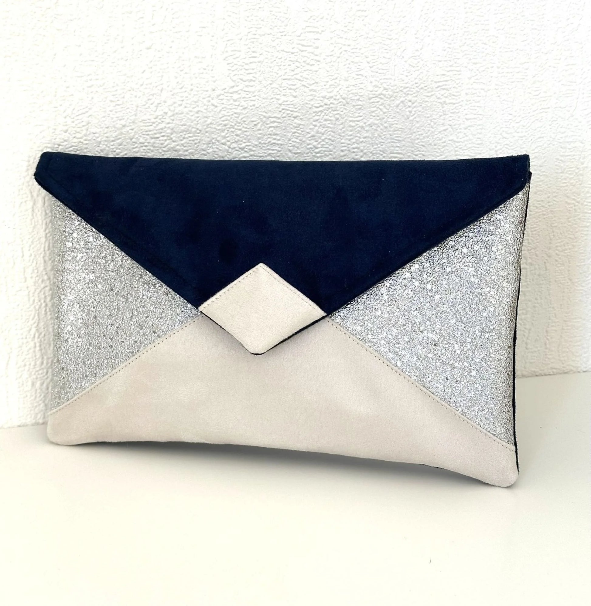 Le sac pochette Isa bleu marine, ivoire et argenté, sans chainette argentée.