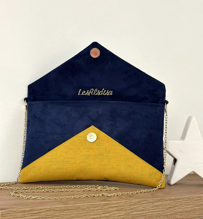 Le sac pochette Isa bleu marine et jaune moutarde à paillettes dorées, ouvert.