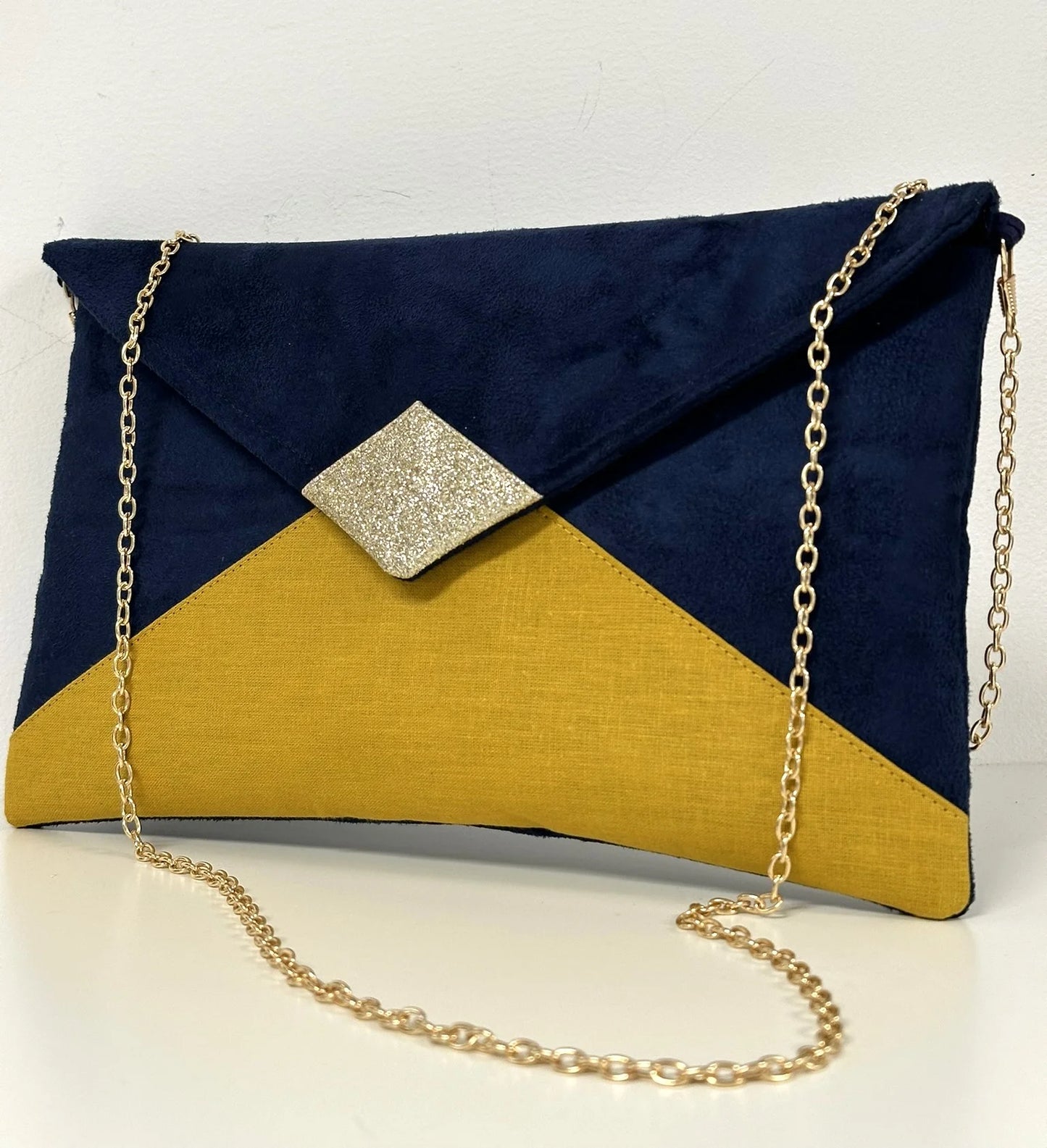 Le sac pochette Isa bleu marine et jaune moutarde à paillettes dorées, face avant.