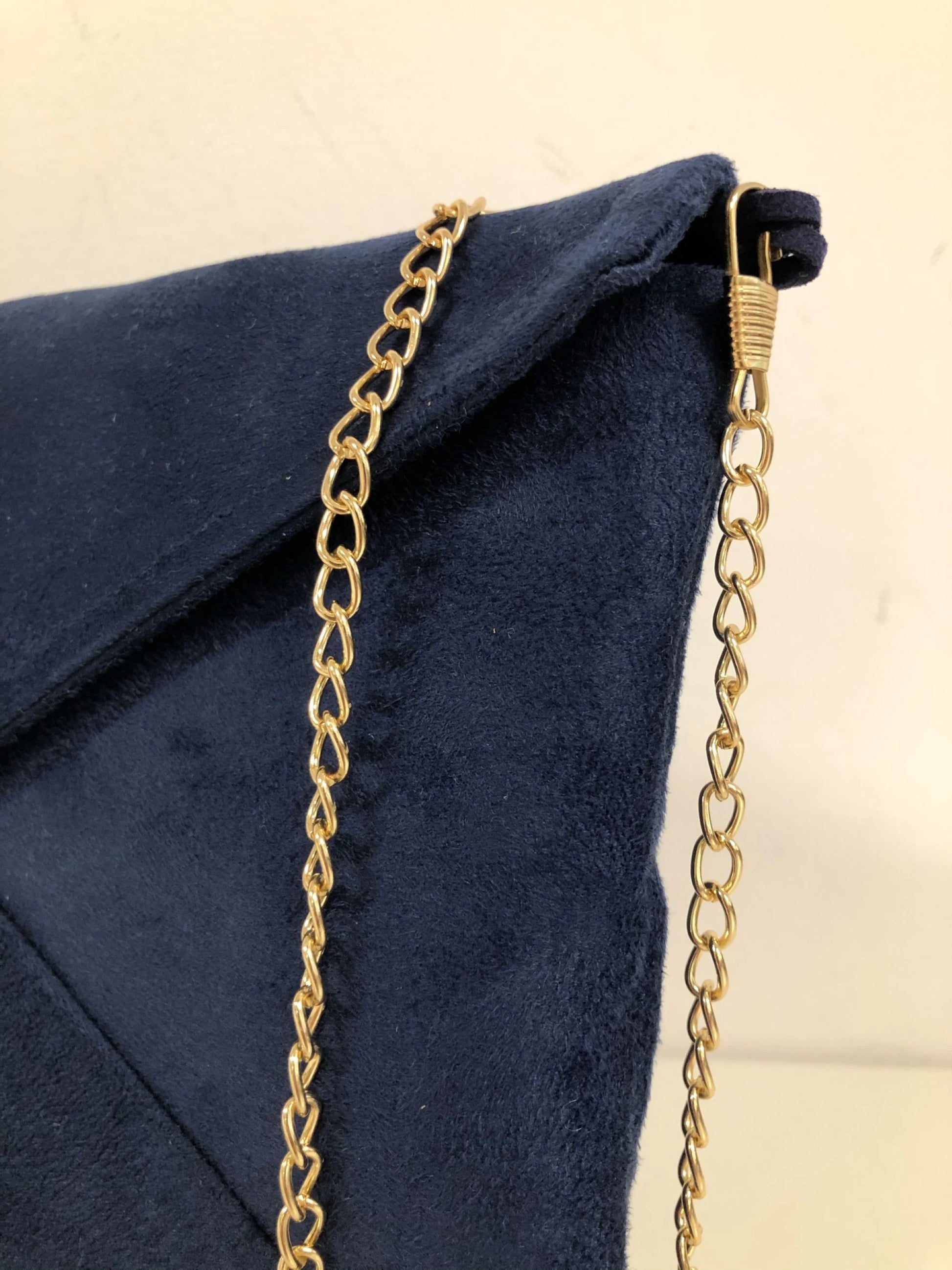 La chainette amovible du sac pochette Isa bleu marine et lin doré.