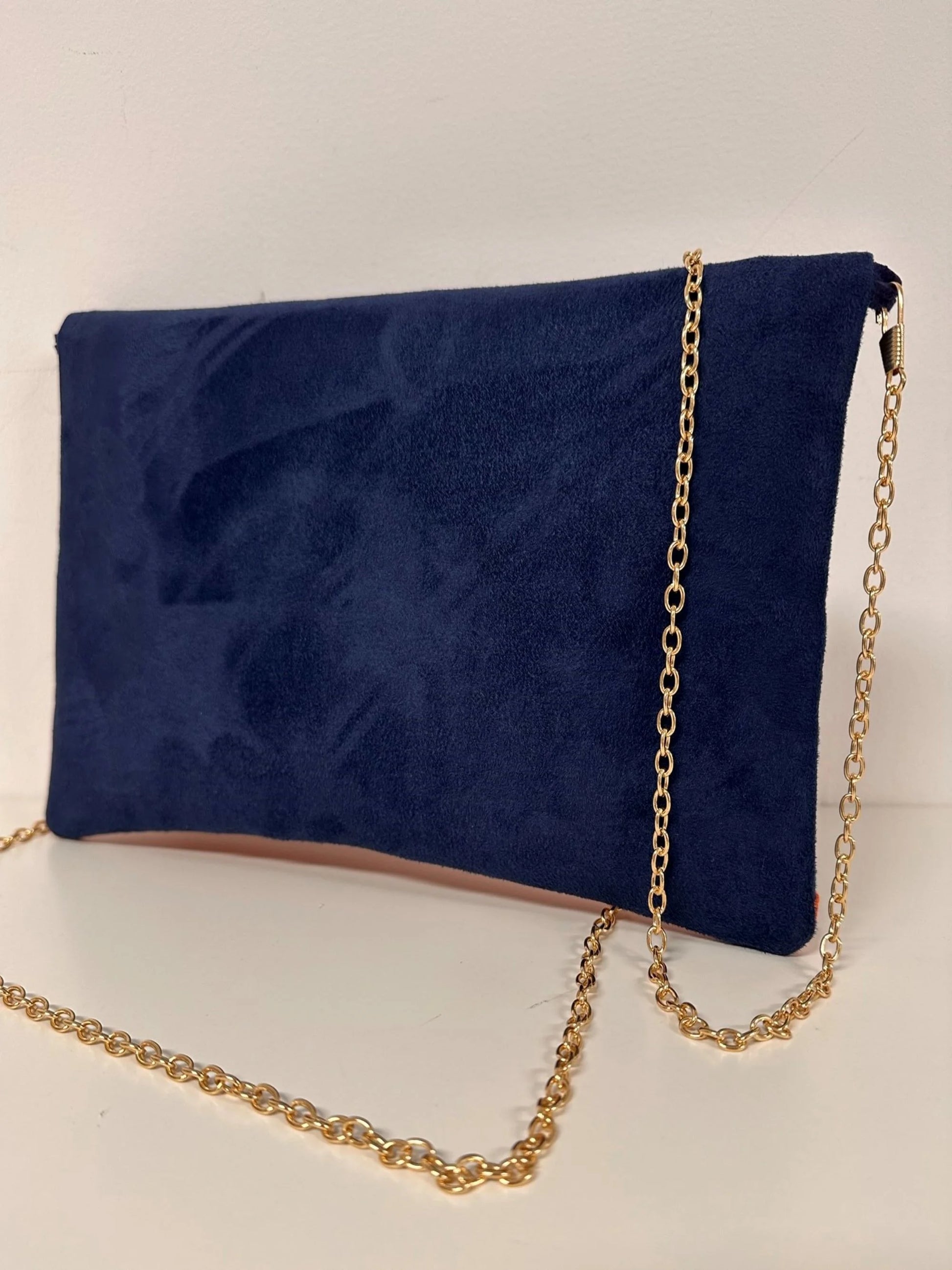 Le sac pochette Isa bleu marine et orange à paillettes, avec chainette dorée, vue de dos.