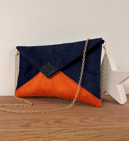 Le sac pochette Isa bleu marine et orange à paillettes, avec chainette dorée, vue de face avant.