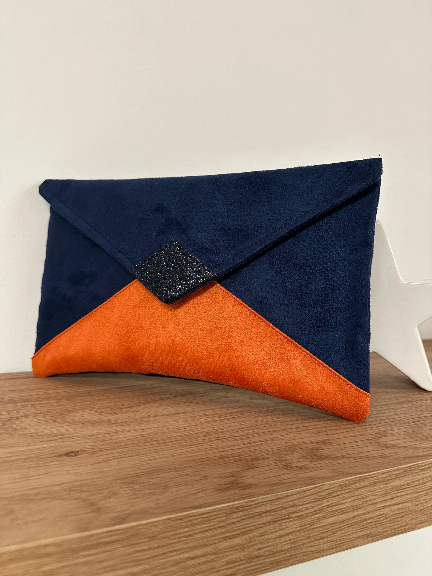 Le sac pochette Isa bleu marine et orange à paillettes, sans chainette .