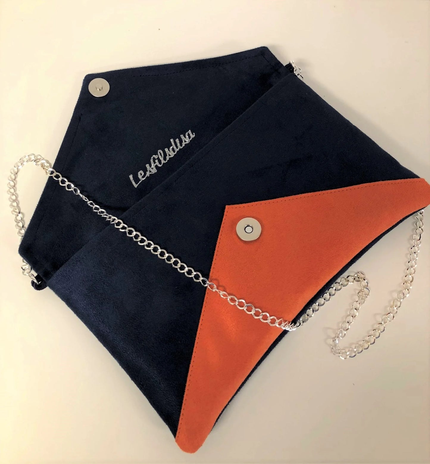 Le sac pochette Isa bleu marine et orange à paillettes argentées, ouvert.