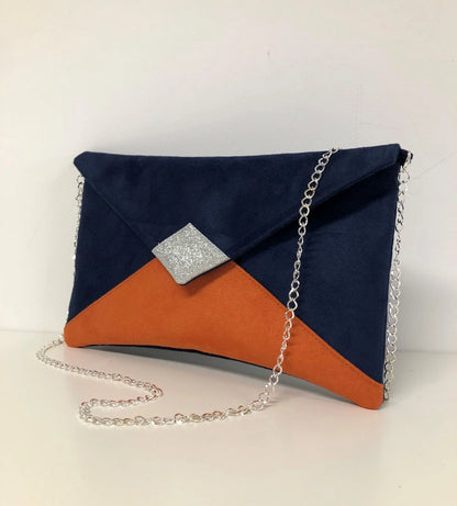 Le sac pochette Isa bleu marine et orange à paillettes argentées, avec chainette amovible.