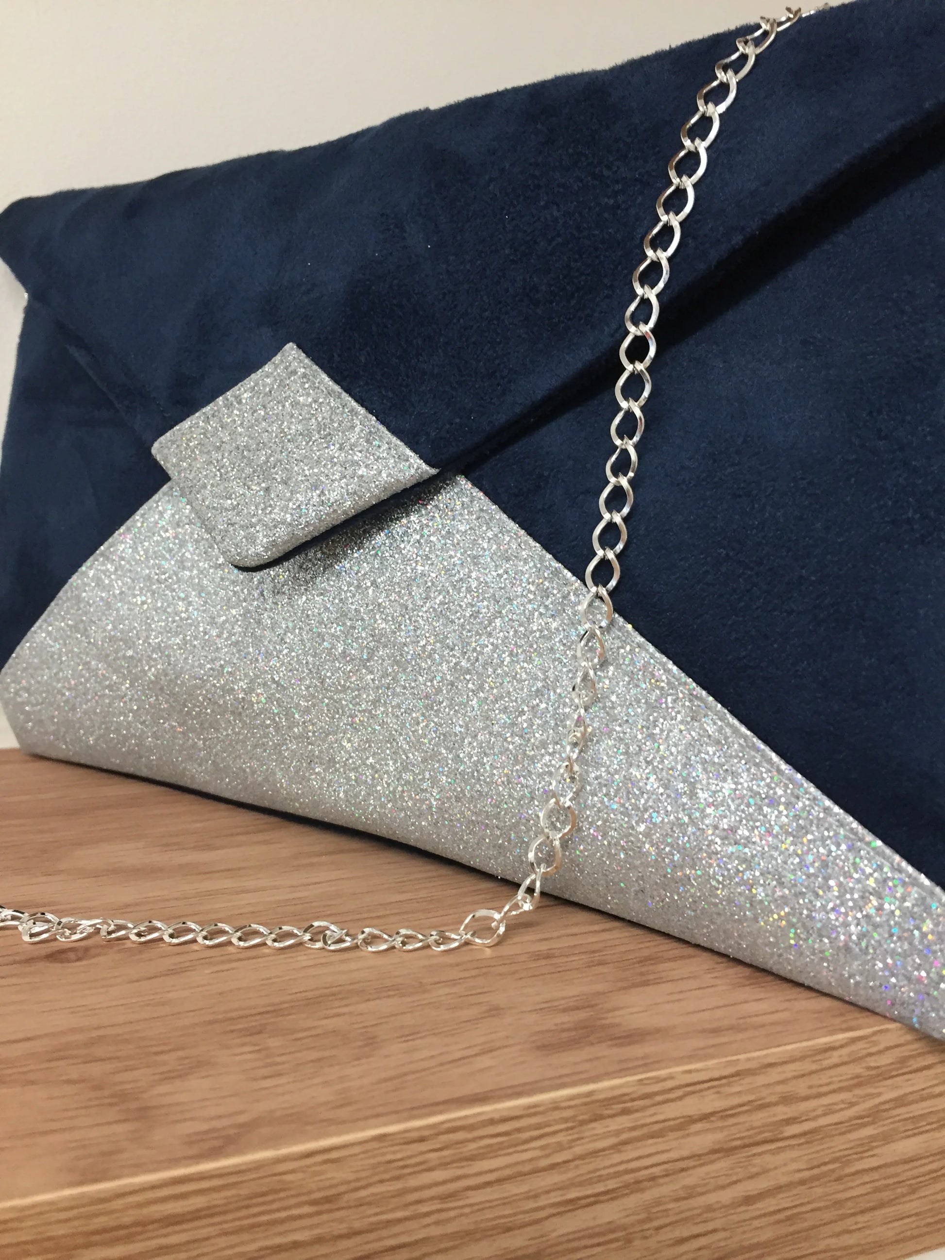 Vue détaillée du sac pochette Isa bleu marine à paillettes argentées, avec la chainette.