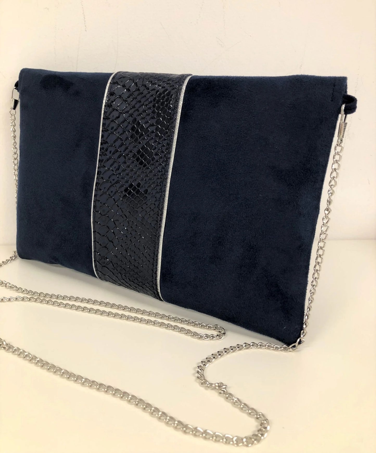 Vue de dos du sac pochette Isa bleu marine reptile à liseré argenté, avec sa chainette amovible.