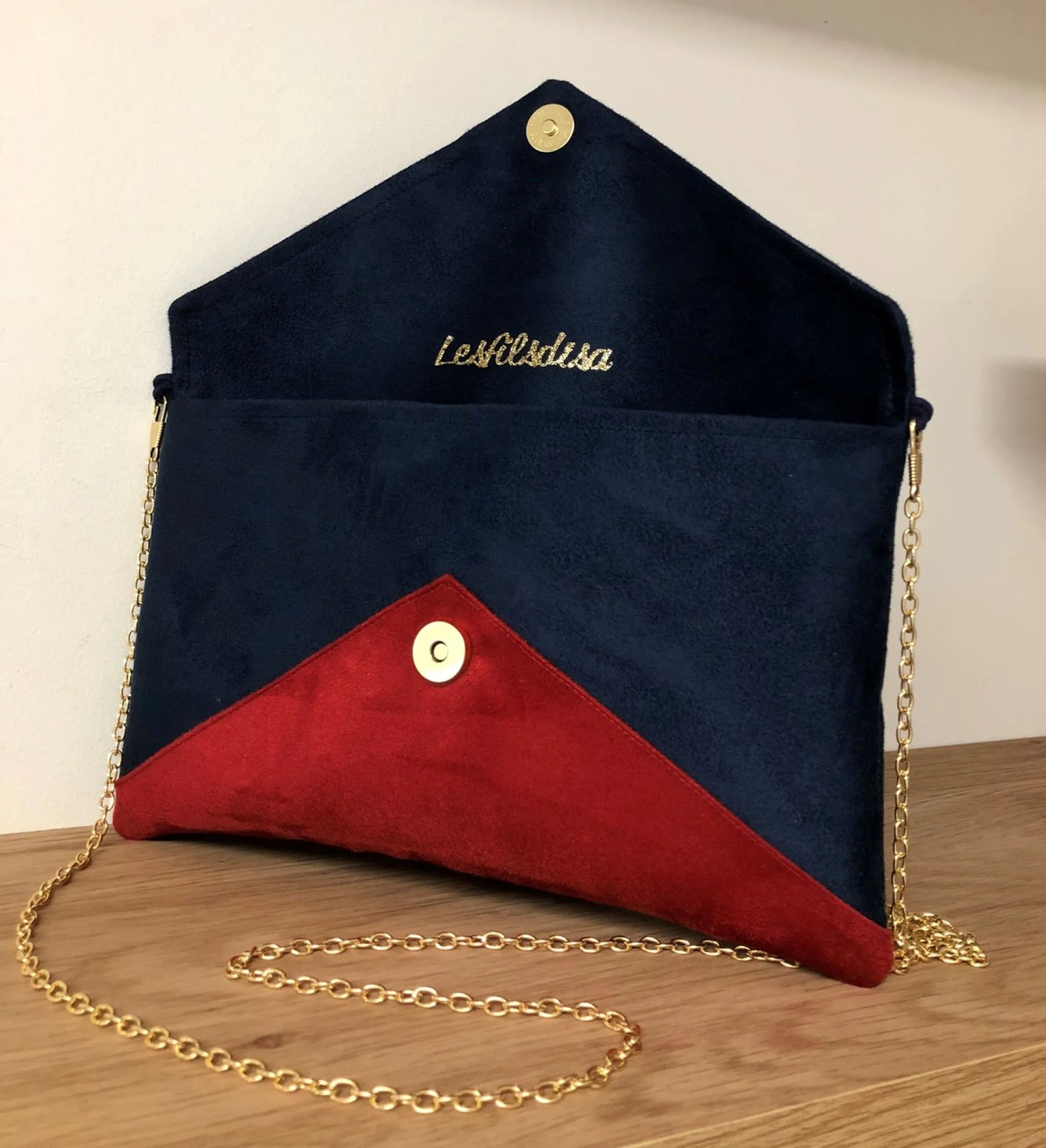 Le sac pochette Isa bleu marine et rouge à paillettes dorées, ouvert.