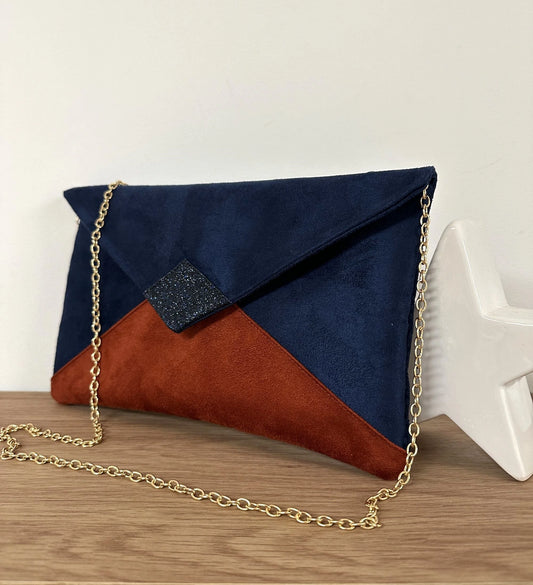 Le sac pochette Isa bleu marine et terracotta à paillettes, avec chainette dorée amovible.