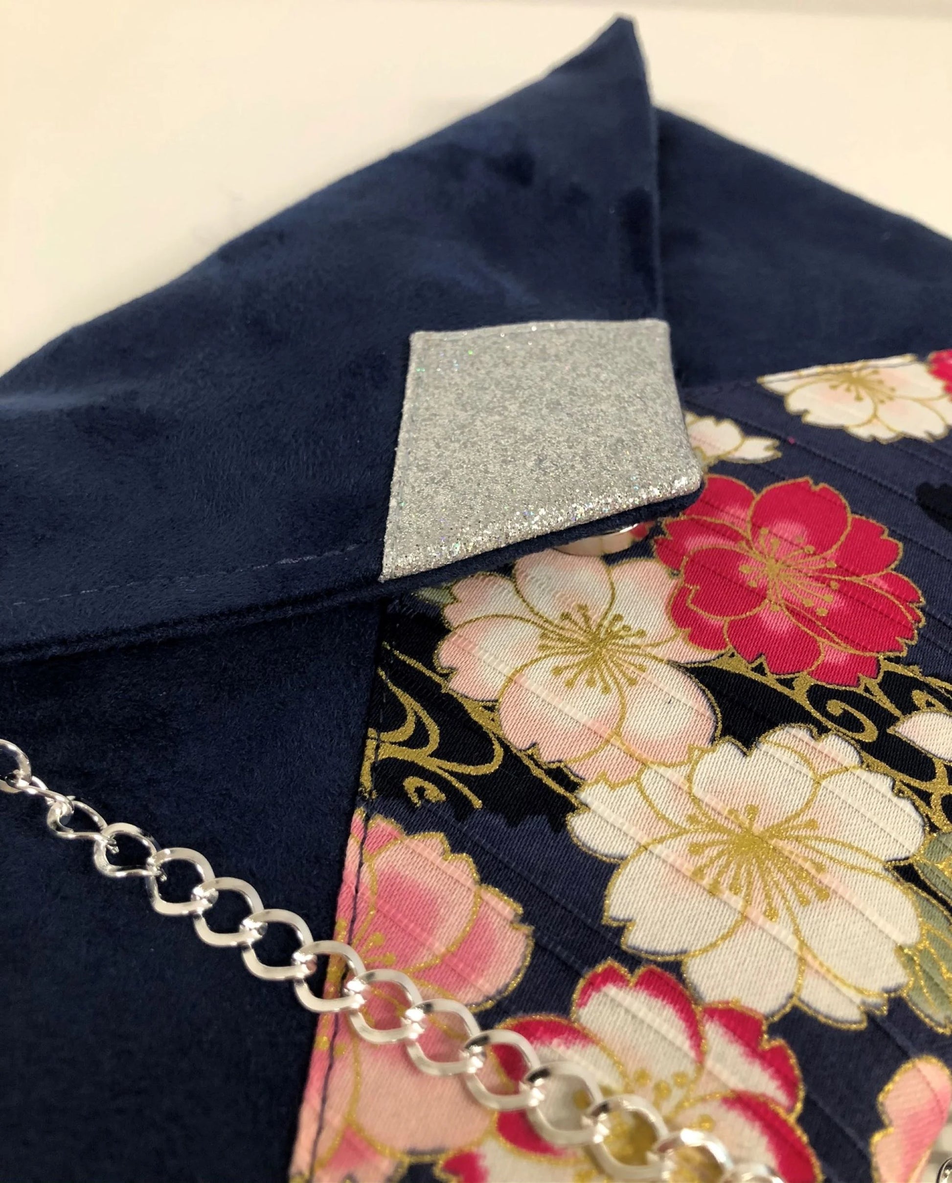 Vue détaillée du sac pochette Isa bleu marine avec tissu japonais fleuri et paillettes argentées.