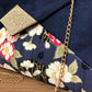 Vue détaillée du sac pochette Isa bleu marine avec tissu japonais fleuri et paillettes dorées
