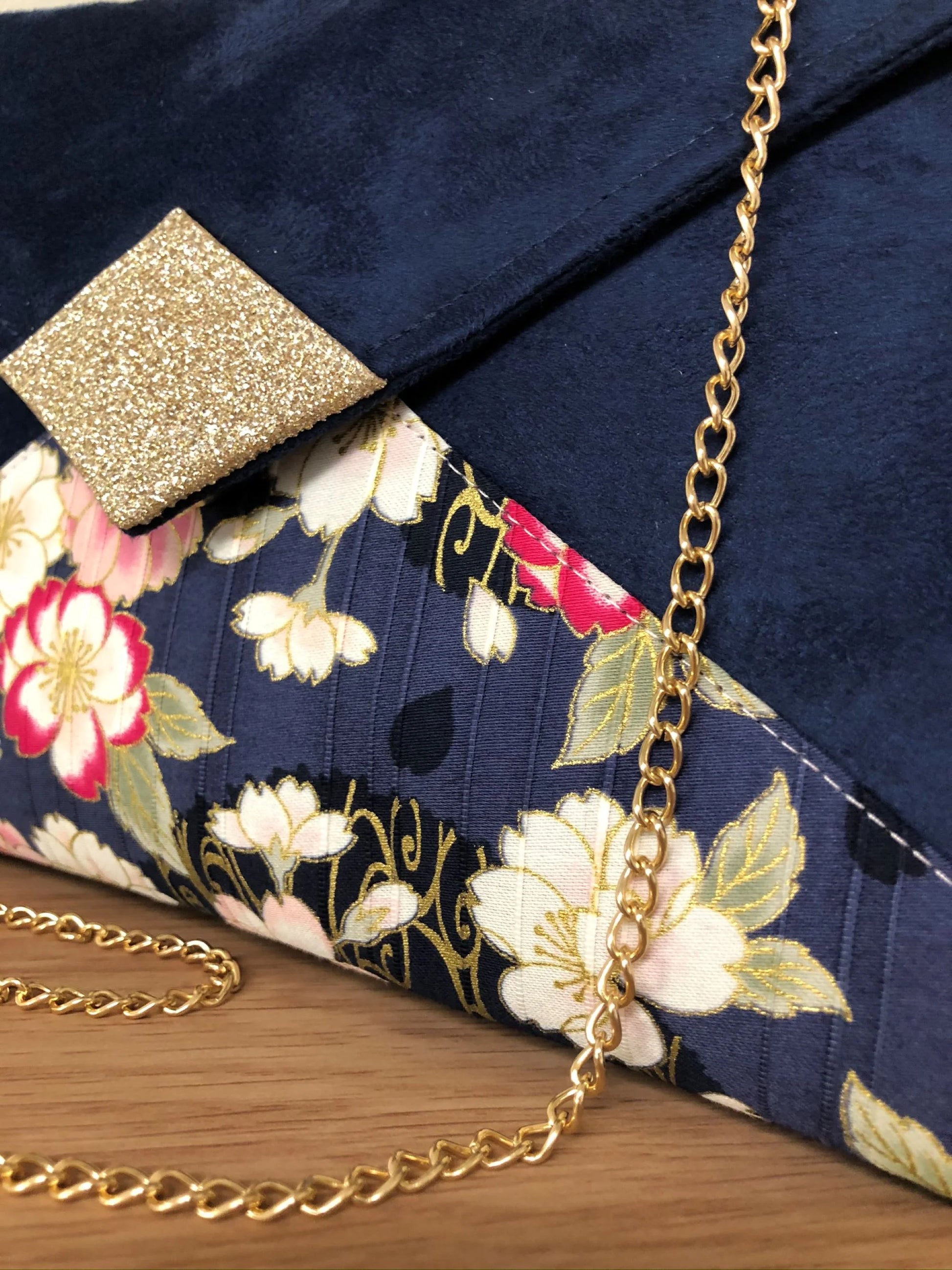 Vue détaillée du sac pochette Isa bleu marine avec tissu japonais fleuri et paillettes dorées