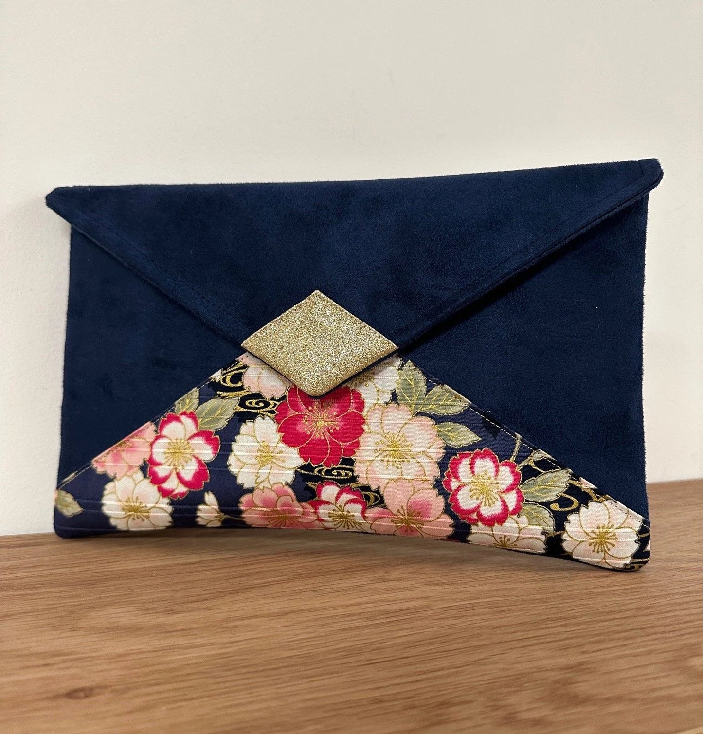 Le sac pochette Isa bleu marine avec tissu japonais fleuri et paillettes dorées sans chainette dorée.