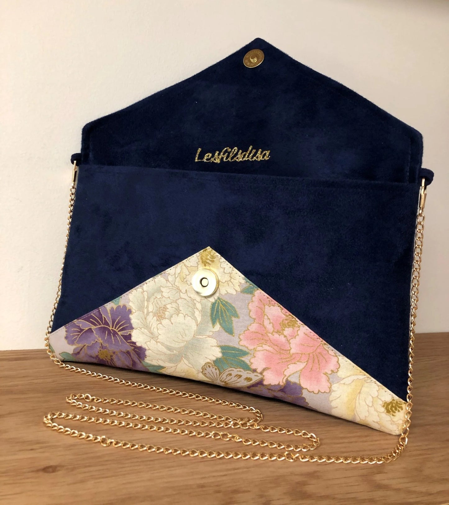 Le sac pochette Isa bleu marine en tissu japonais à fleurs mauve et rose et paillettes dorées, ouvert.