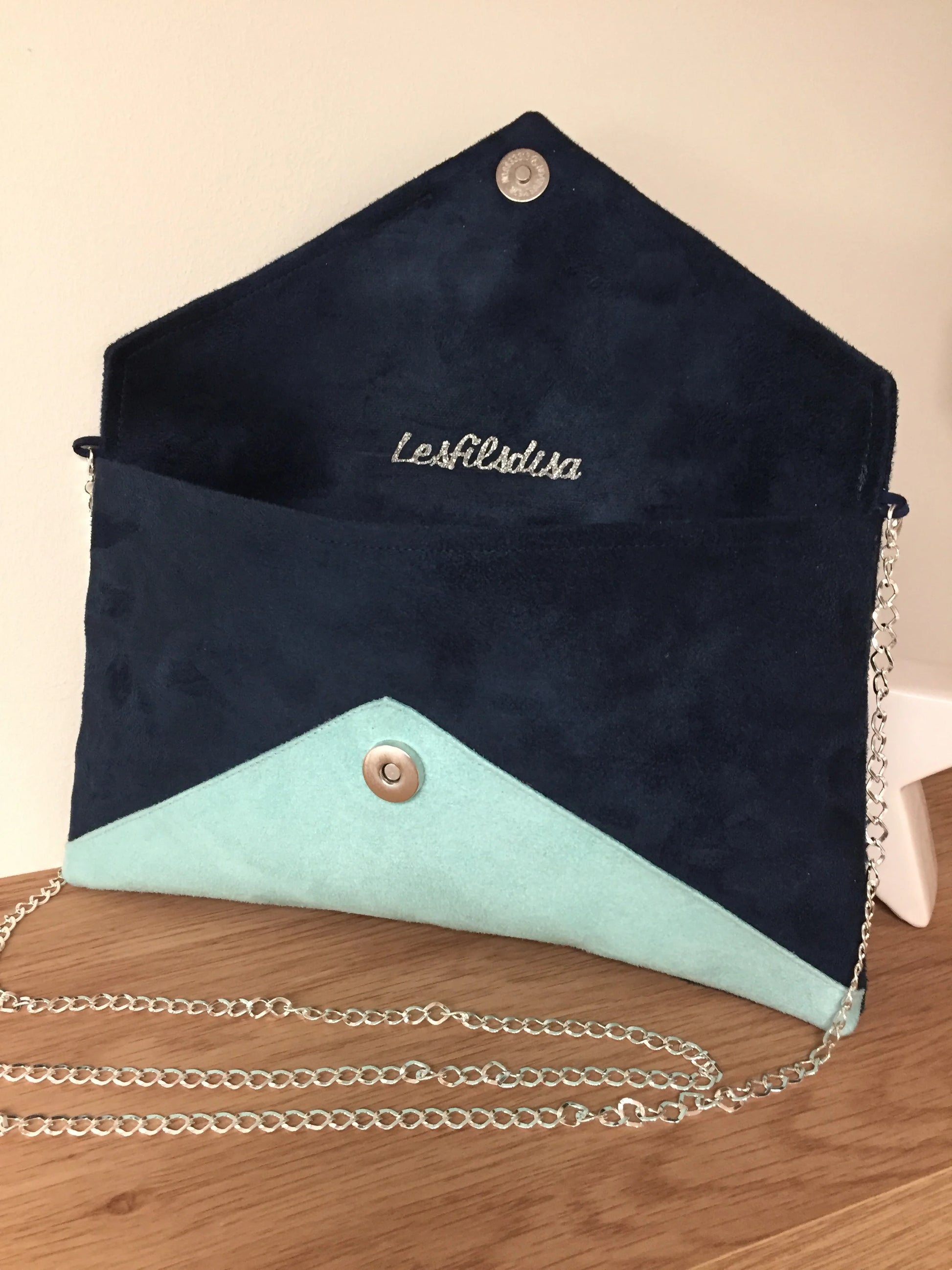 Le sac pochette Isa bleu marine et vert menthe à paillettes argentées, avec chainette amovible, ouvert.