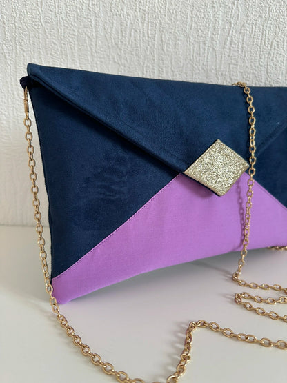 Vue latérale du sac pochette Isa bleu marine violet et doré avec sa chainette dorée amovible.