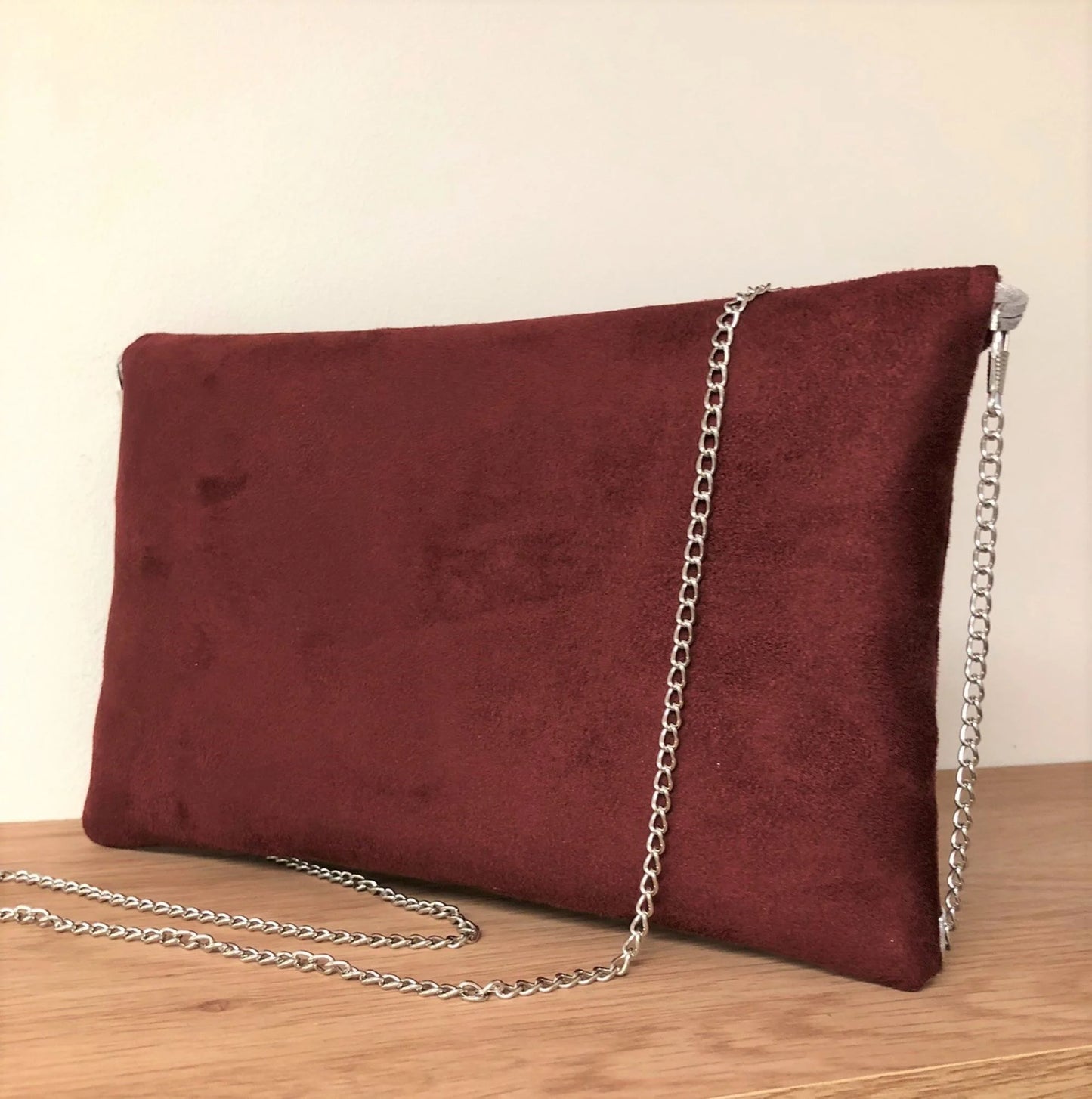 Le dos du sac pochette Isa bordeaux à paillettes argentées.