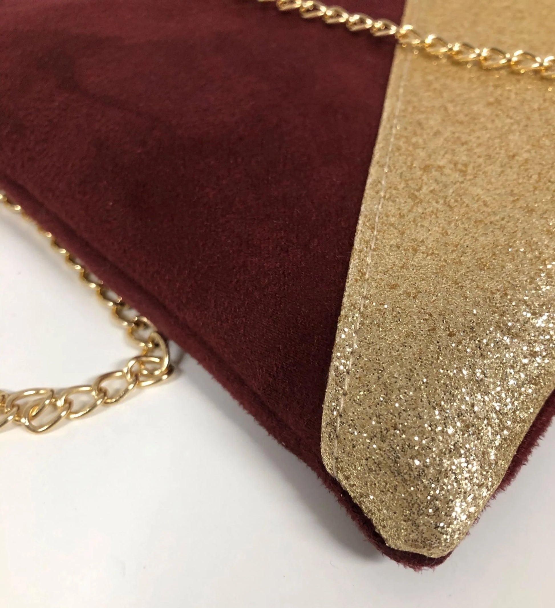 Vue détaillée du sac pochette Isa bordeaux à paillettes dorées.