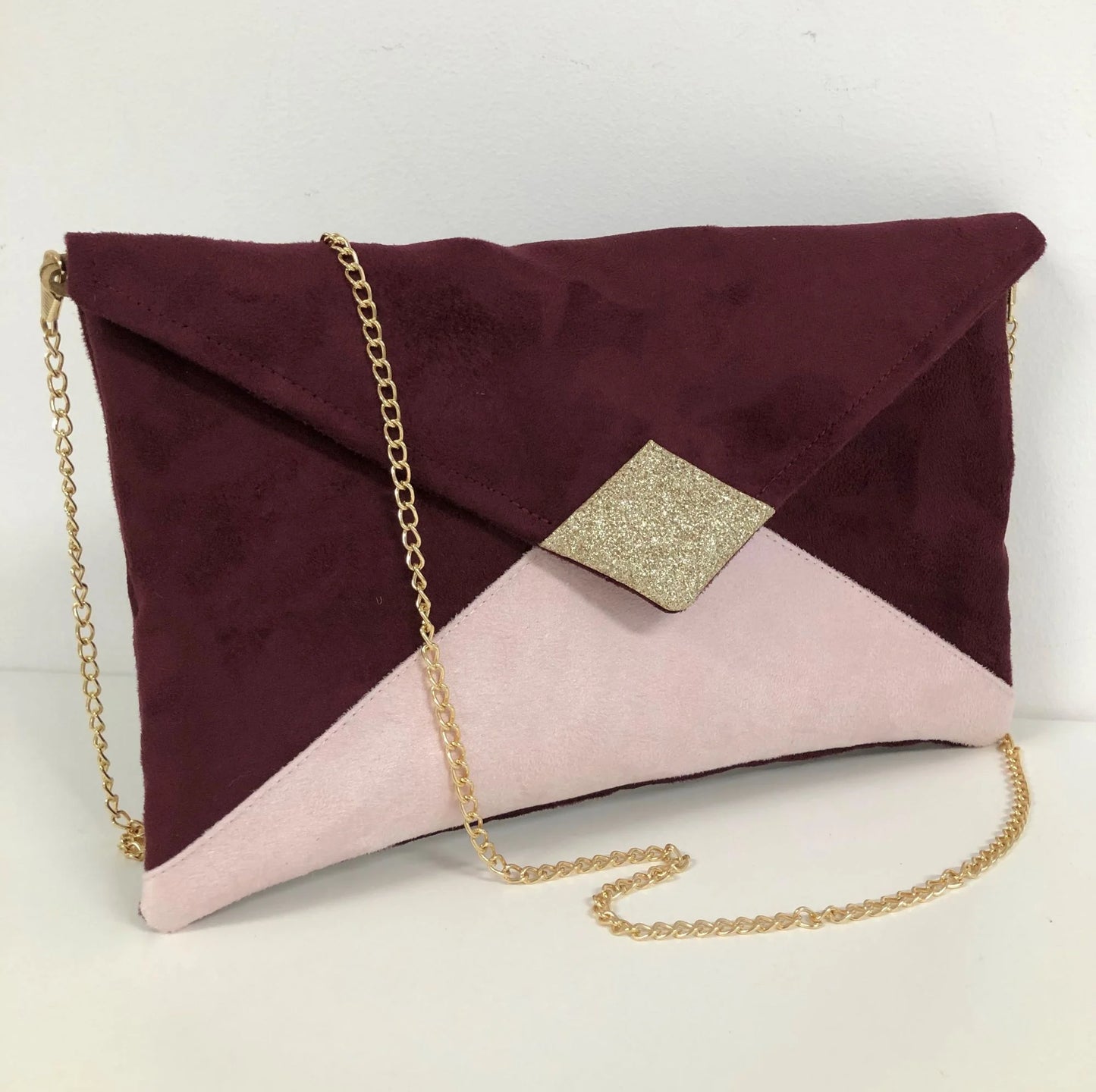 Le sac pochette Isa bordeaux et rose pâle à paillettes dorées