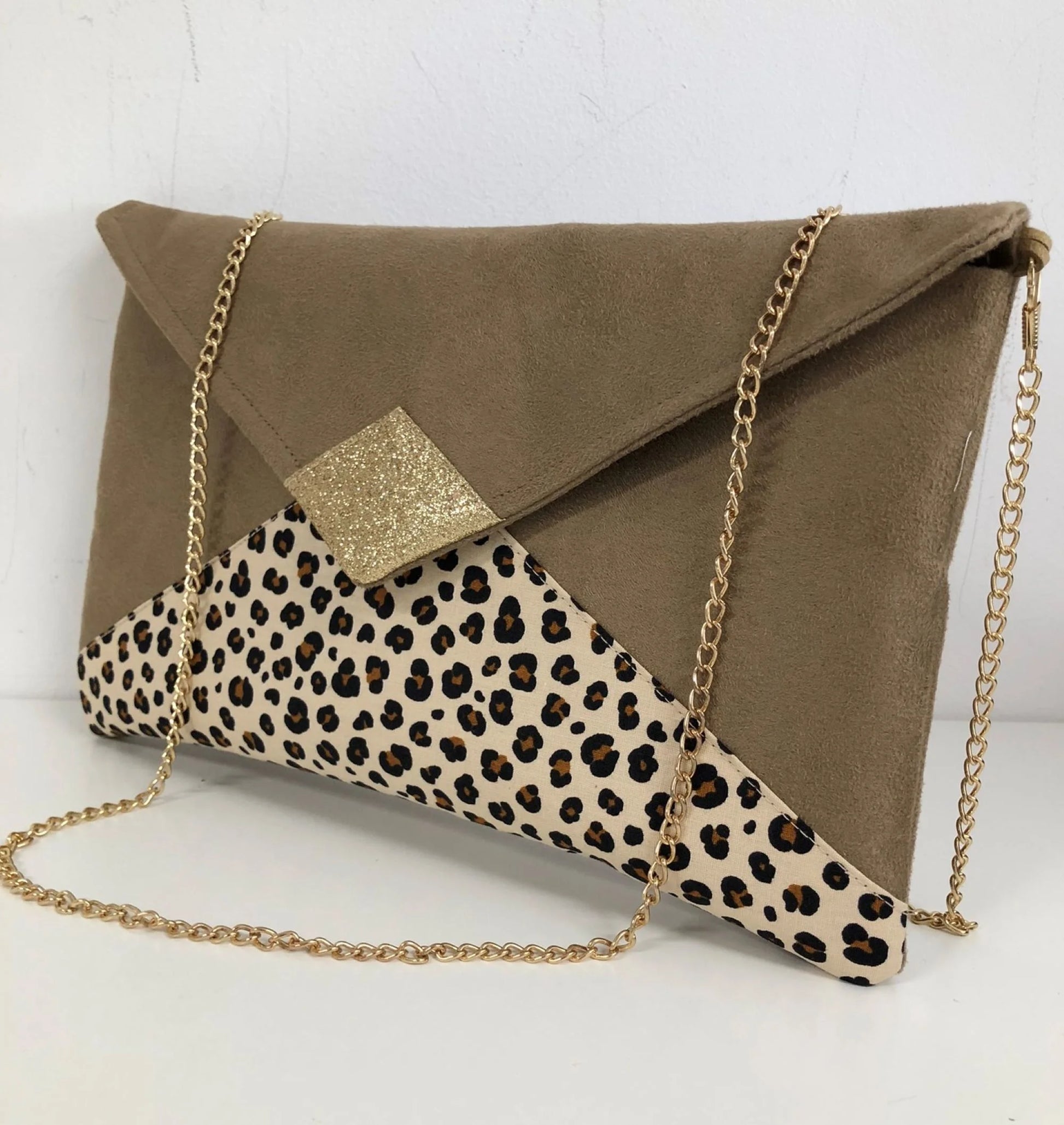 le sac pochette Isa camel à motif animal et paillettes dorées, avec sa chainette amovible.