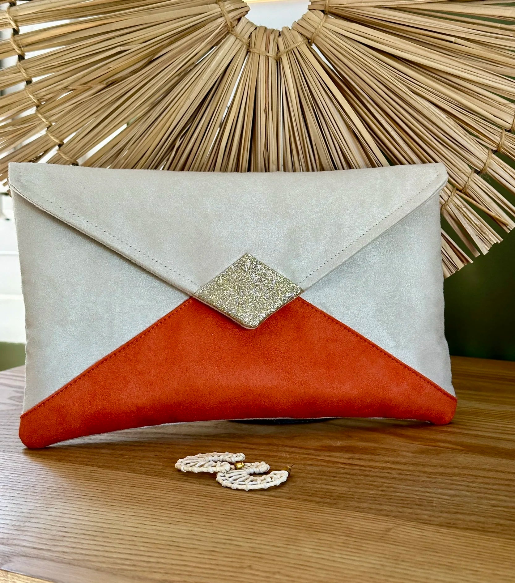 Le sac pochette Isa écru et orange à paillettes dorées, sans chainette.