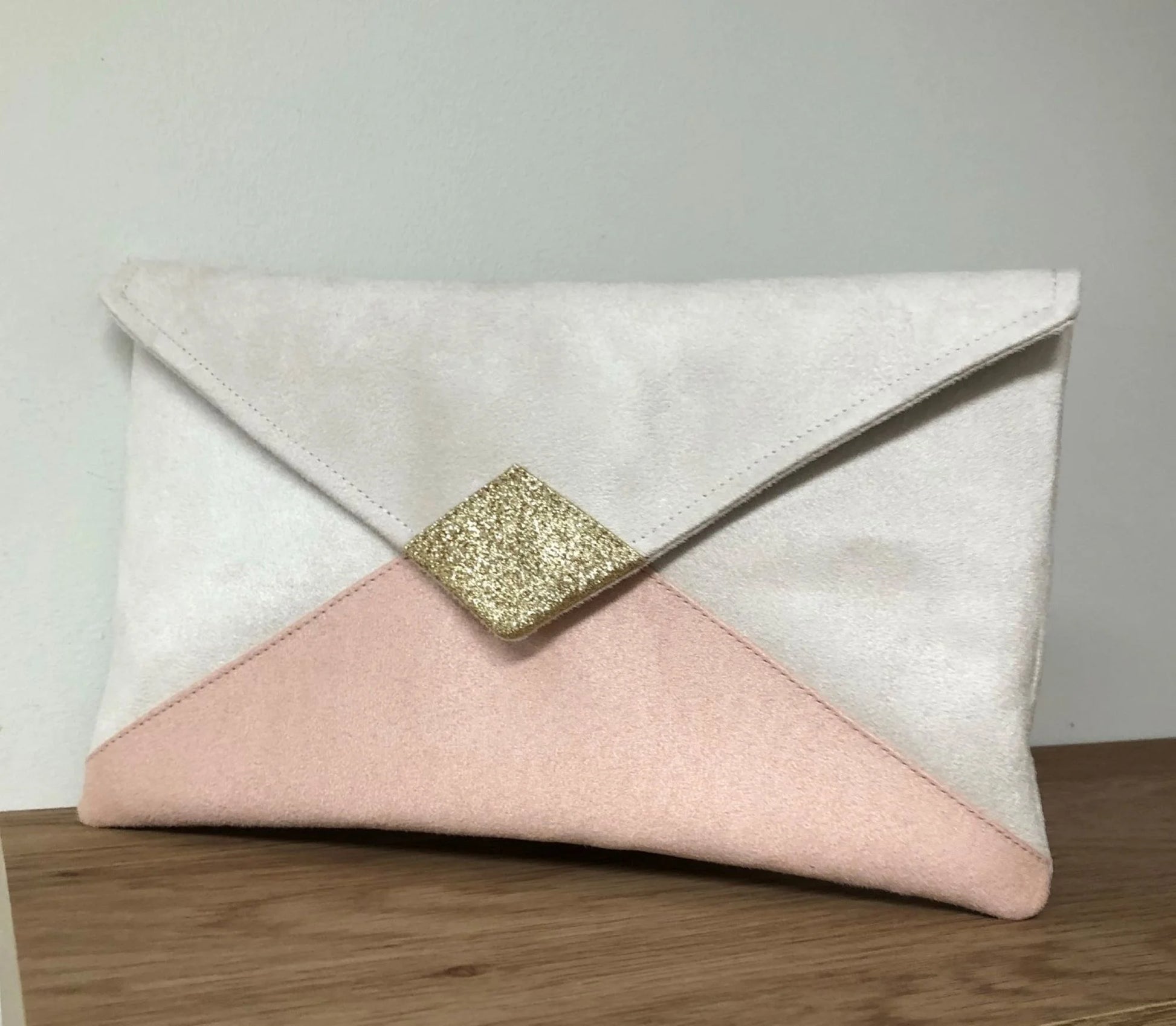 Le sac pochette Isa écru et rose poudré à paillettes dorées, sans chainette.