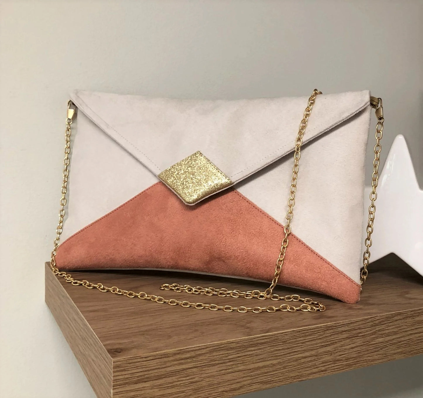 Le sac pochette Isa écru et rose saumon à paillettes dorées, avec chainette amovible.