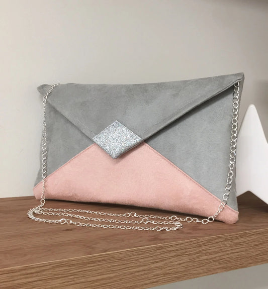 Le sac pochette Isa gris clair et rose poudré à paillettes argentées, avec sa chainette amovible.
