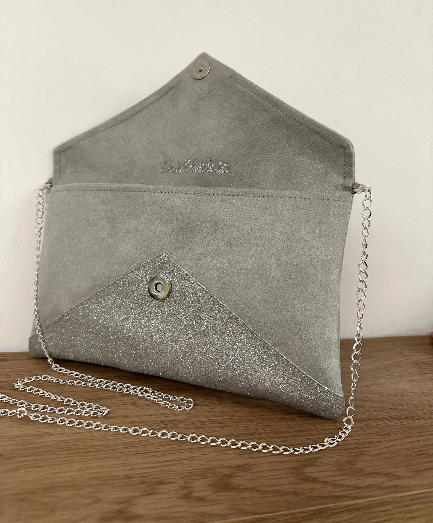 le sac pochette Isa gris perle à paillettes argentées, ouvert.