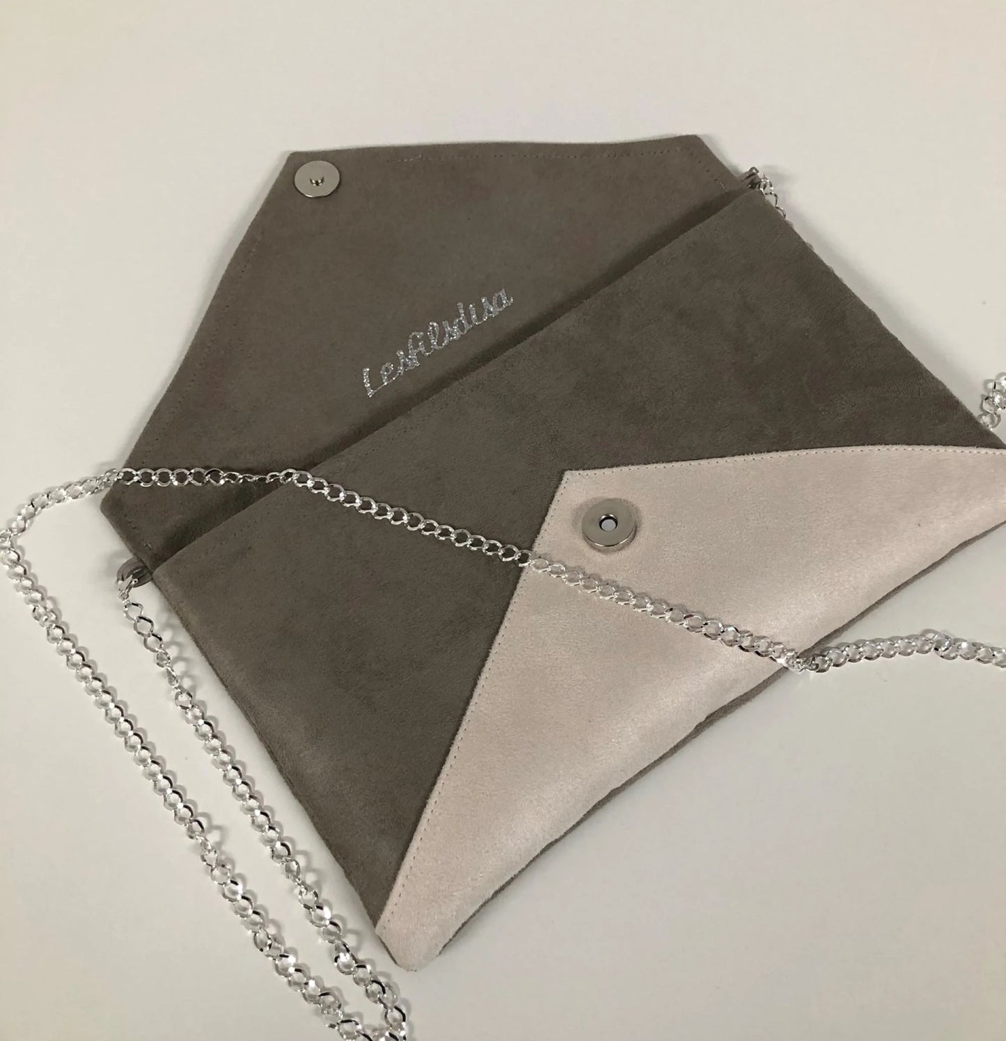 Le sac pochette Isa gris taupe et écru à paillettes argentées, ouvert, avec chainette.