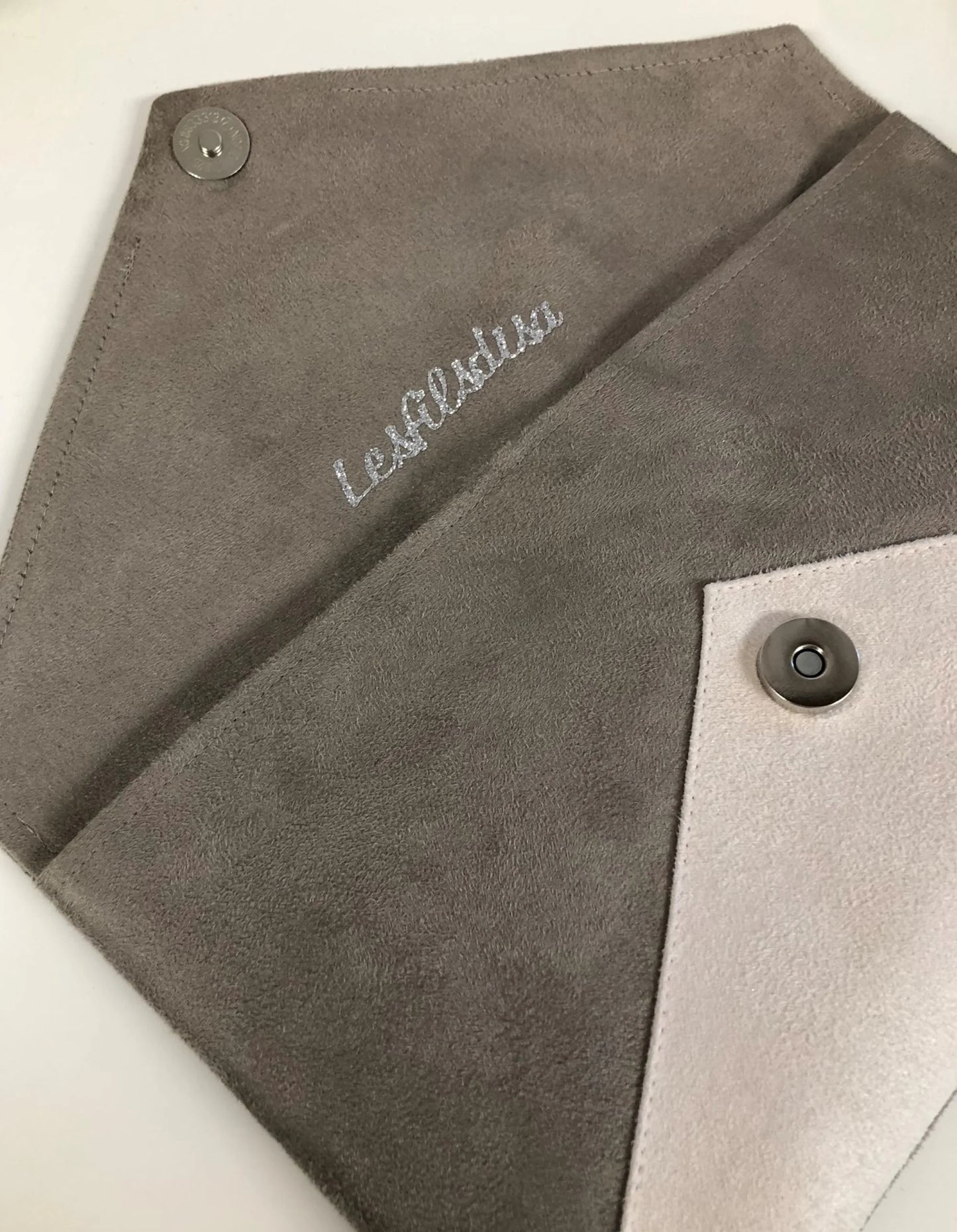 Le sac pochette Isa gris taupe et écru à paillettes argentées, ouvert, sans chainette.