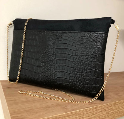 Le dos du sac pochette Isa noir mat aspect reptile, ici avec chainette dorée amovible.