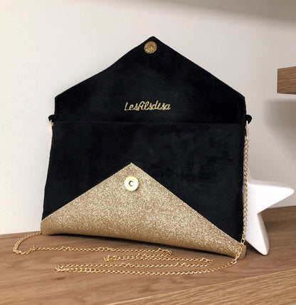 Le sac pochette Isa noir à paillettes dorées, ouvert, avec chainette amovible.