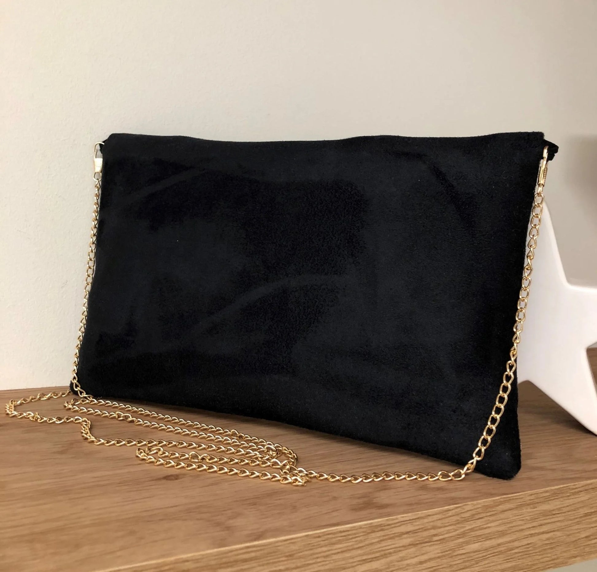 Le dos du sac pochette Isa noir à paillettes dorées, avec chainette amovible.