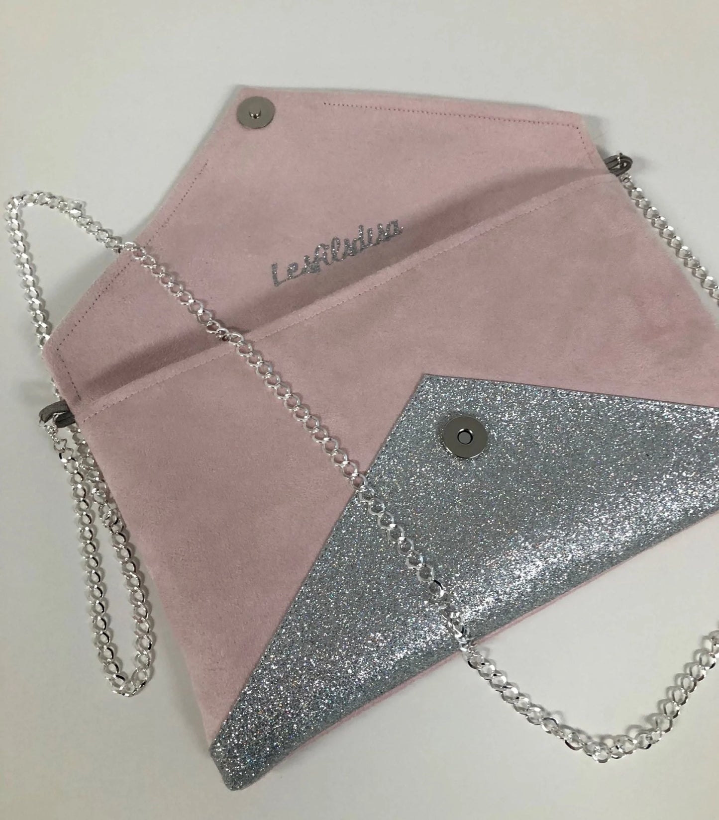 Vue ouverte du sac pochette Isa rose pâle à paillettes argentées.