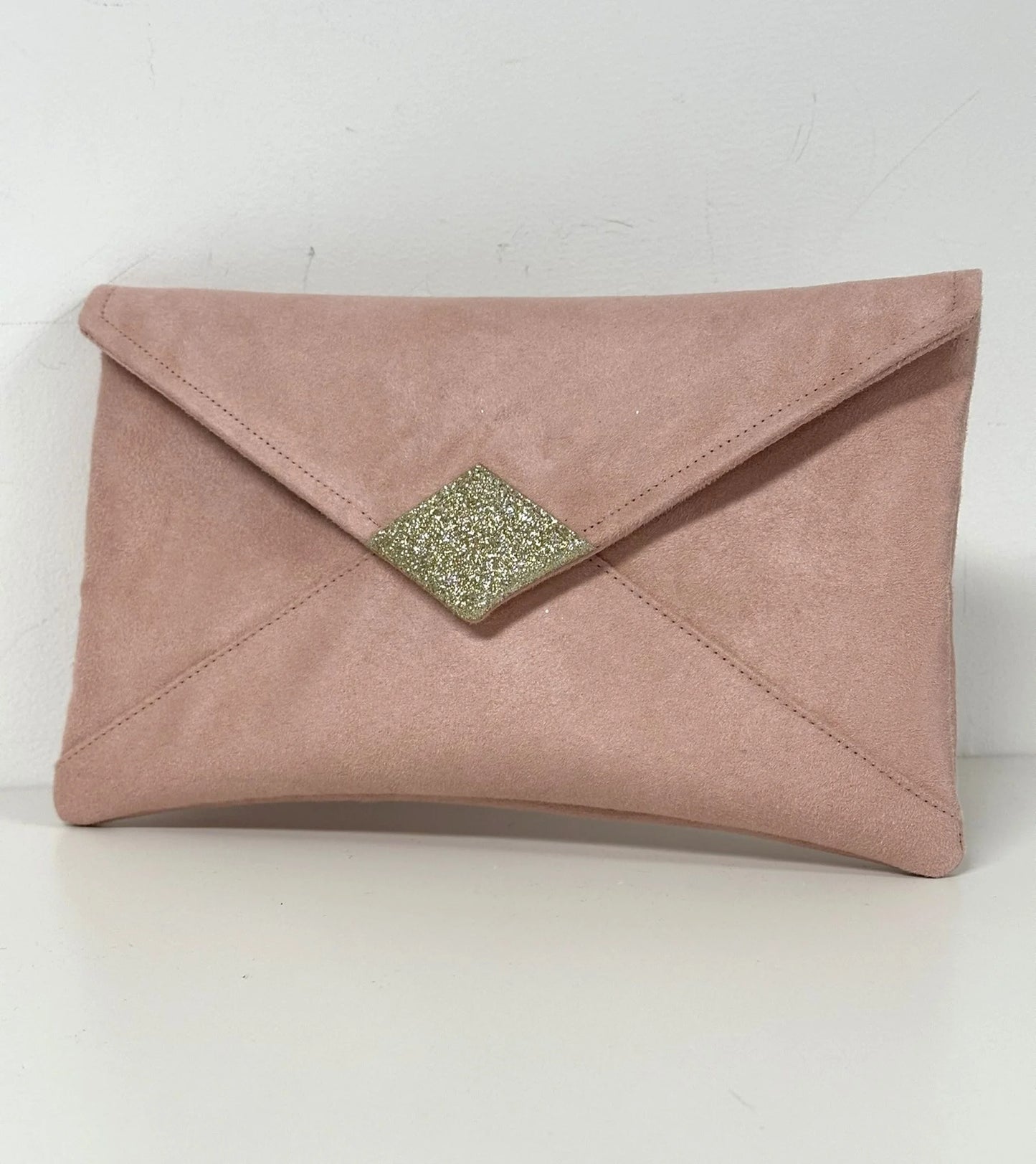 Le sac pochette Isa rose poudré à paillettes dorées, sans chainette.