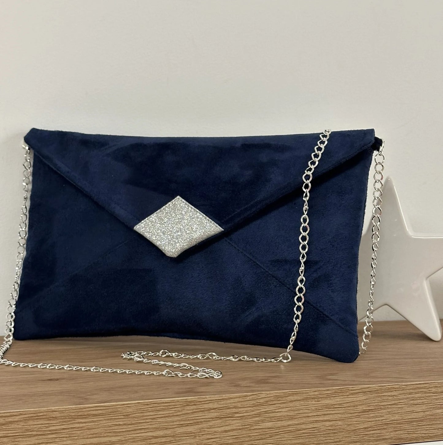 Le sac pochette Isa en suédine bleu marine et paillettes argentées, avec chainette amovible.