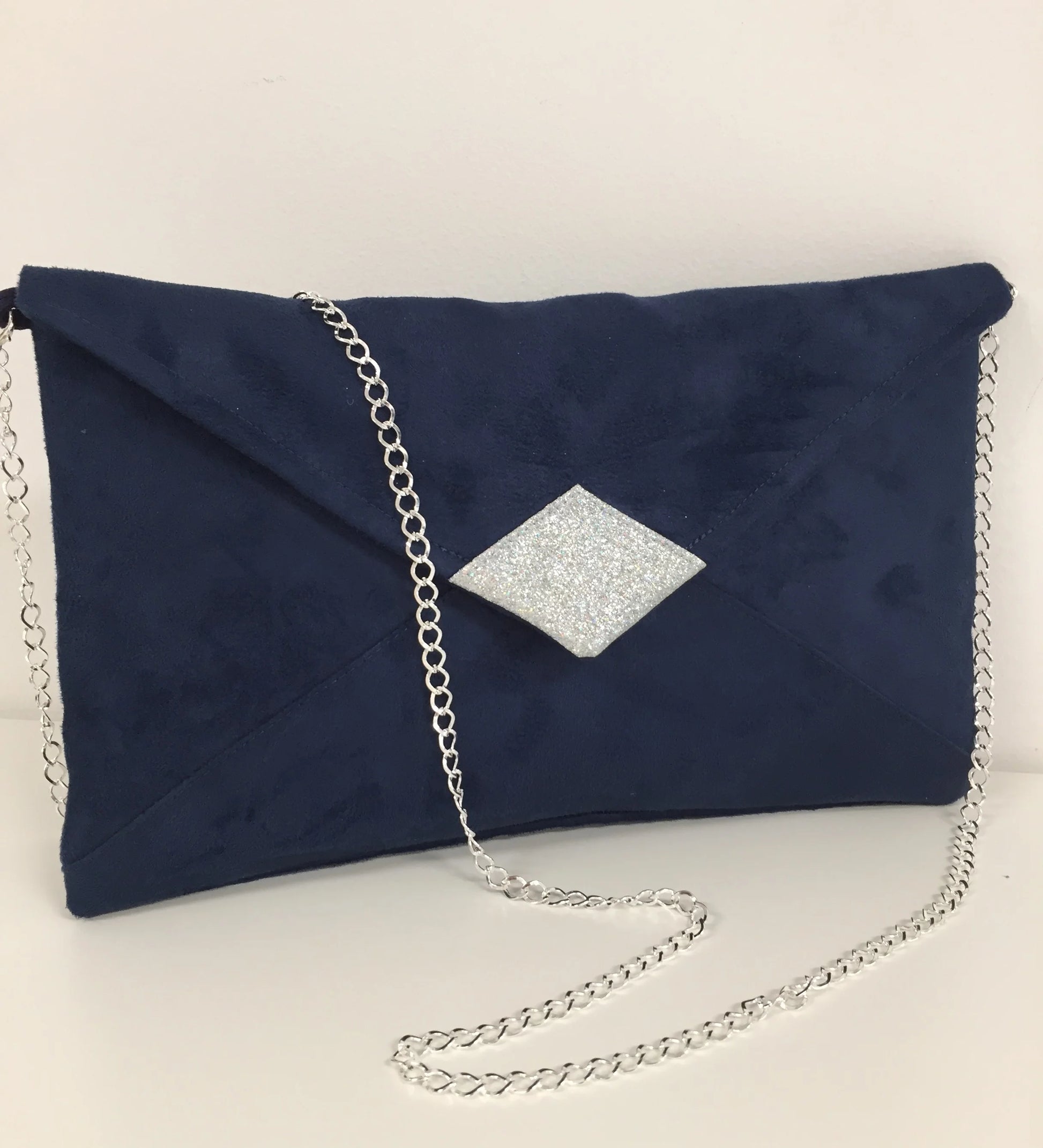 Le sac pochette Isa en suédine bleu marine avec paillettes argentées et chainette amovible.